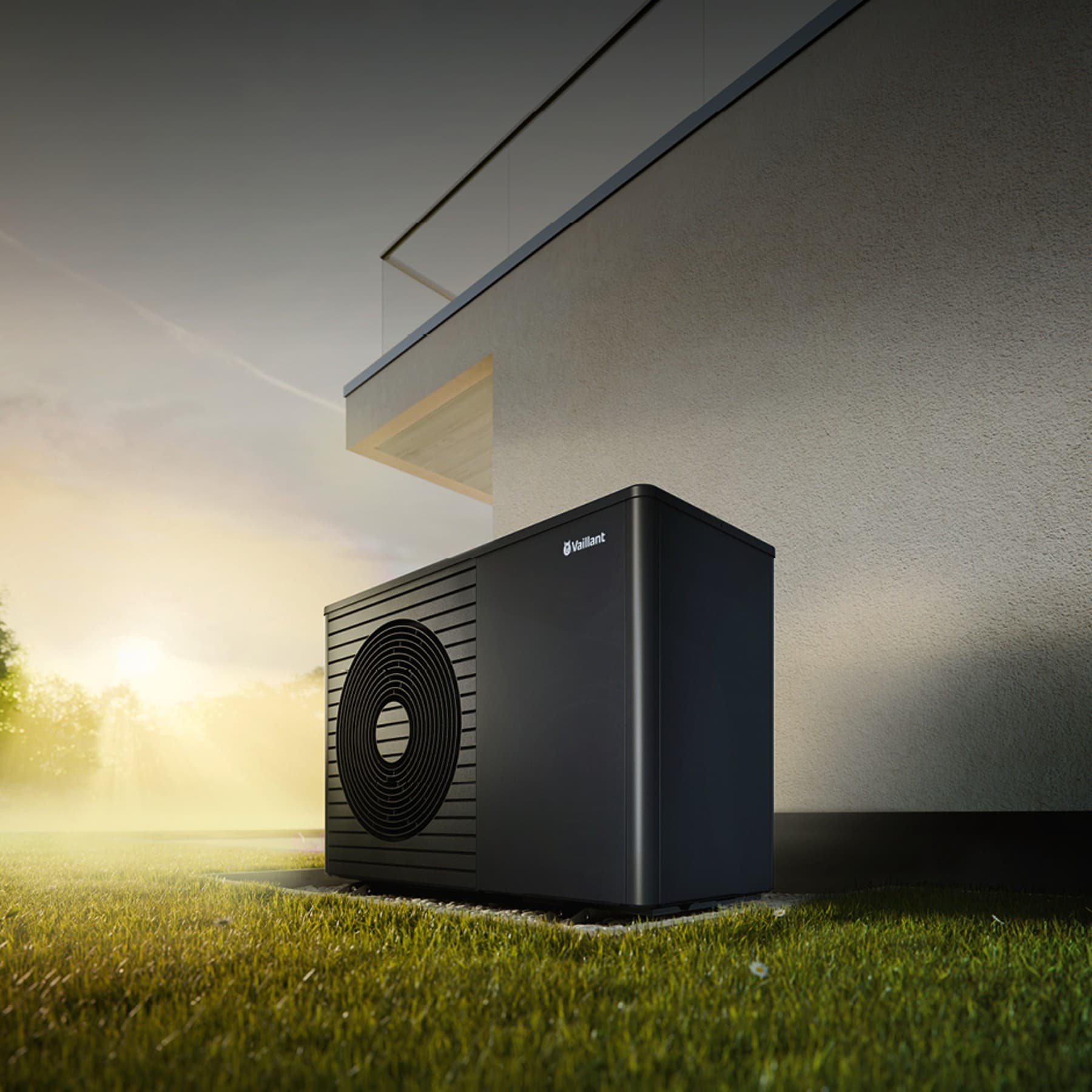 Wärmepumpe aroTHERM plus im Garten vor einer weißen Hauswand. Im Hintergrund sind Bäume und ein Sonnenaufgang zu sehen.